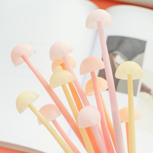 Yellow, orange, and pink thin mushroom tops at the end of a pen.